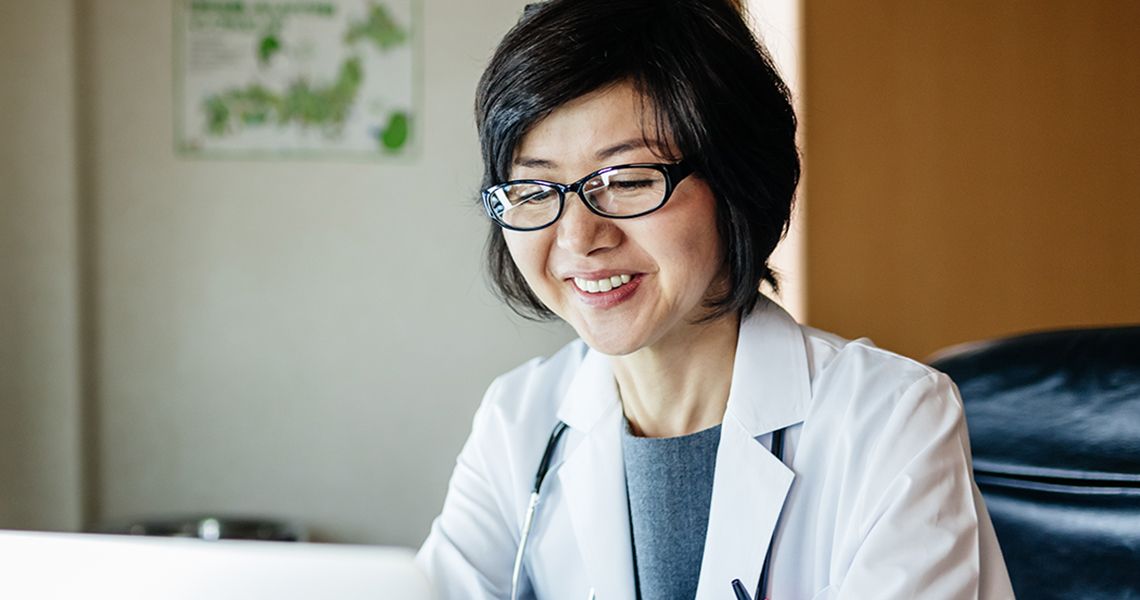 Doctor looking at a computer and smiling