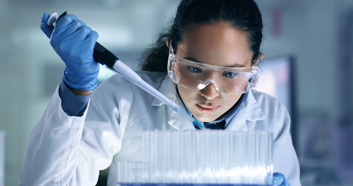 researcher using a pipette in a lab