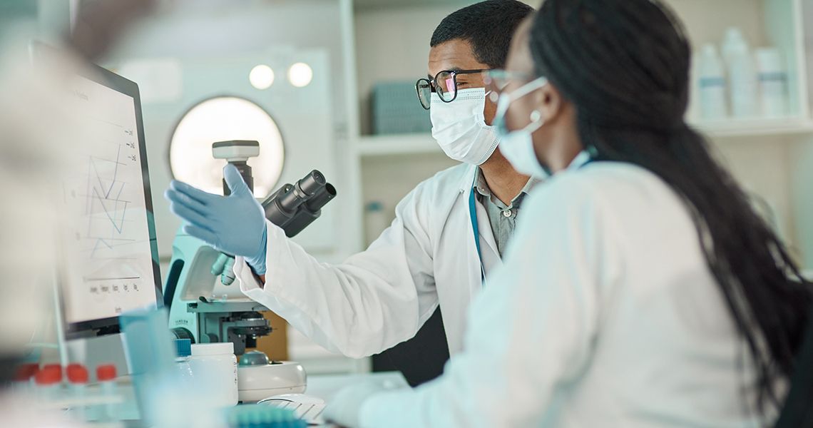 two scientists talking to each other in a lab